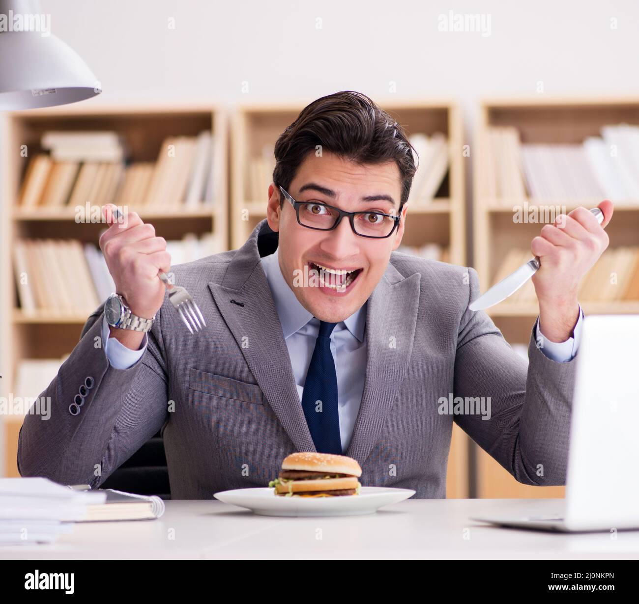 Hambre gracioso empresario comiendo comida basura sandwich Foto de stock
