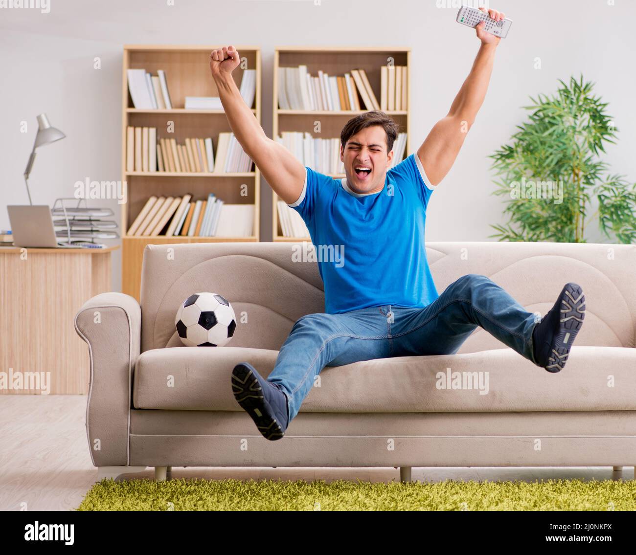Hombre viendo el fútbol en casa Foto de stock