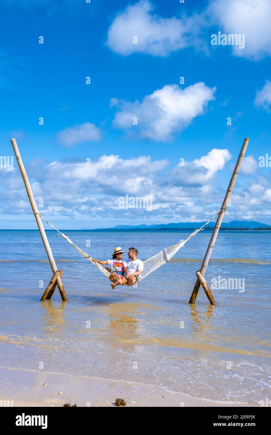 Relajarse en la hamaca en la playa, bajo un árbol, un día de verano. Barefoot  hombre tendido en la hamaca, mirando a un lago, inspirador paisaje  Fotografía de stock - Alamy