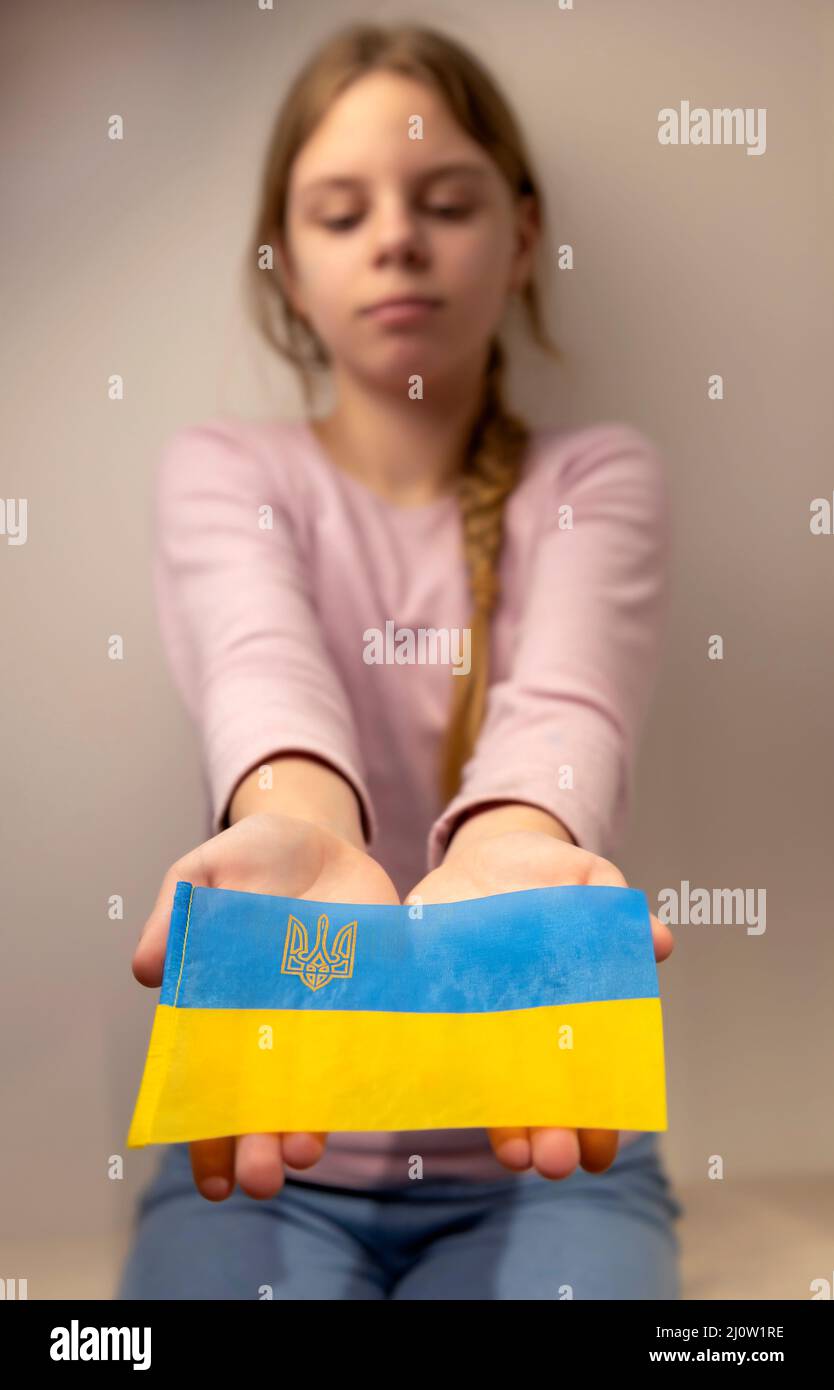 Retrato de una niña de 13 años con una bandera ucraniana azul y amarilla. El niño tiene la bandera ucraniana. El patriotismo ama a la Patria. Foto de stock