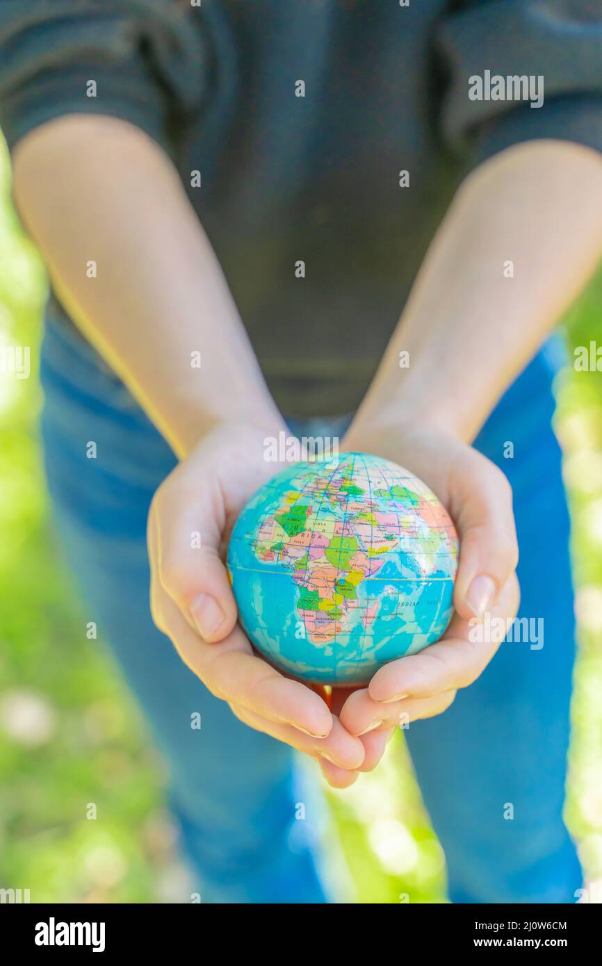 Manos humanas sosteniendo la bola de tierra global. Sustentar el