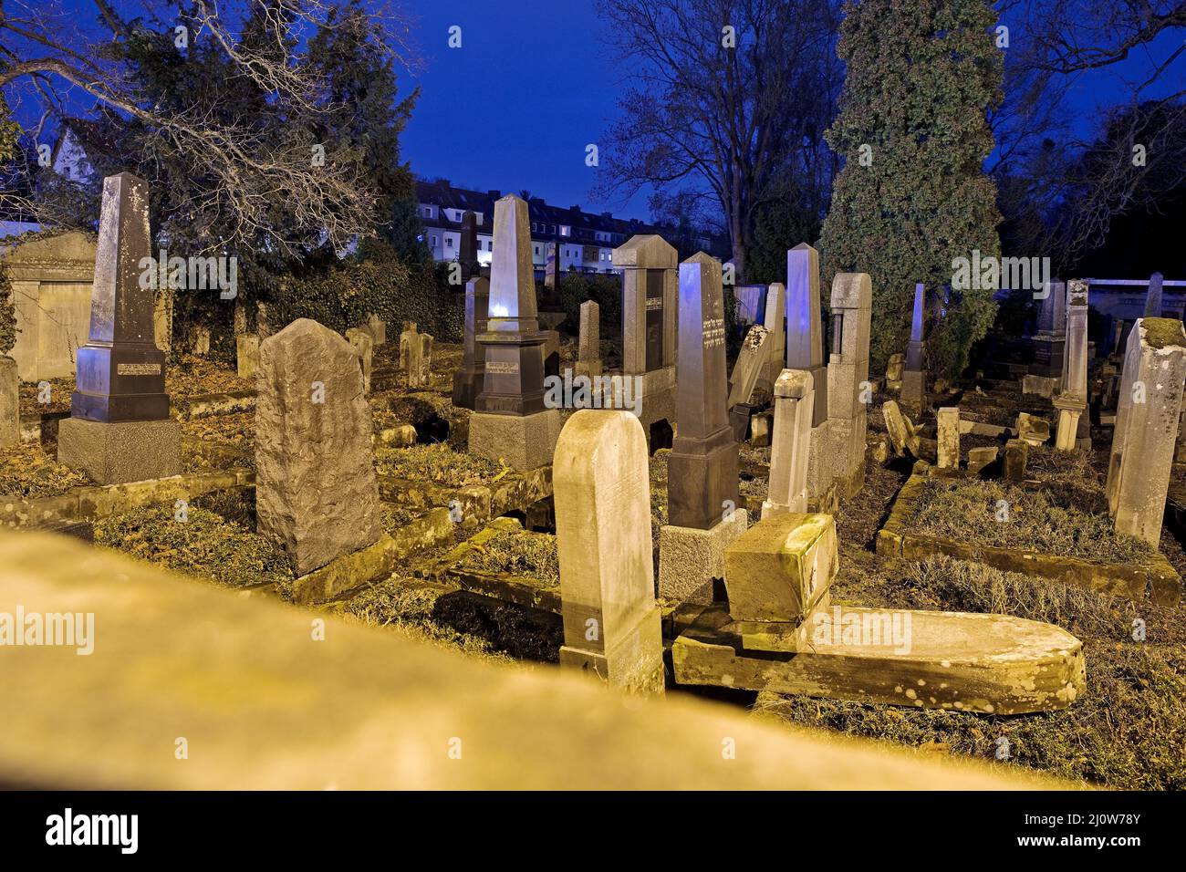 Cementerio judío por la noche, en el fondo de los edificios residenciales, Goettingen, Alemania, Europa Foto de stock