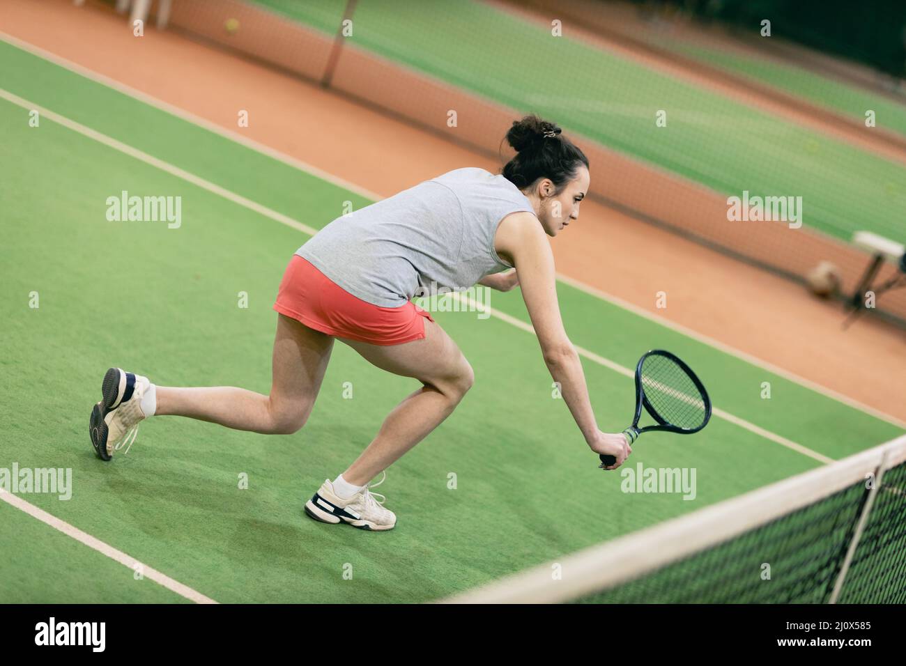 Tenista mujer jugando entrenamiento con raqueta y pelota en la cancha Foto de stock