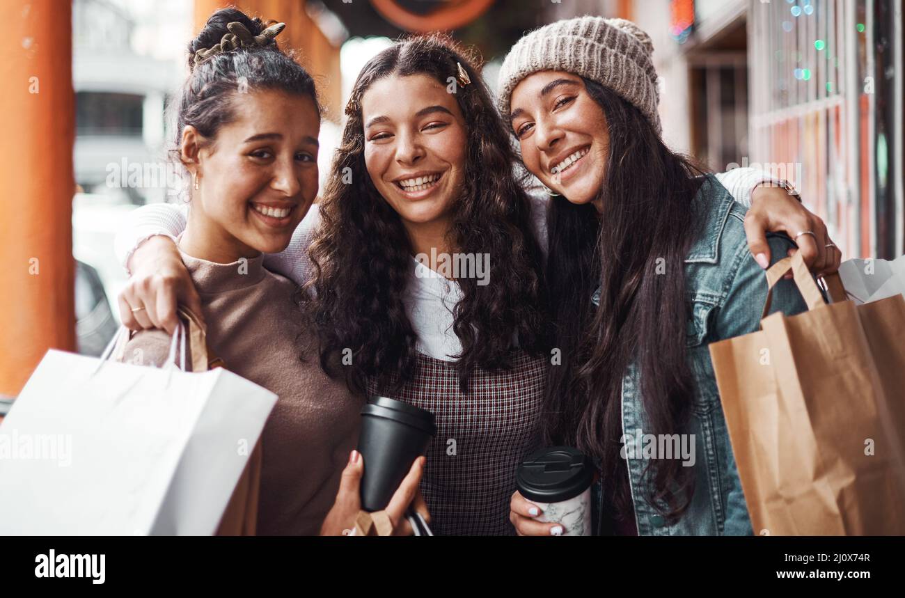 Nada puede venir entre nosotros. Retrato recortado de un atractivo grupo de hermanas que se unen durante una serie de compras en la ciudad. Foto de stock