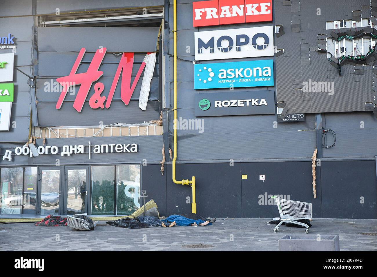 Kiev, Ucrania. 21st Mar, 2022. (NOTA DE LOS EDITORES: La imagen muestra la  muerte)Los cuerpos de víctimas no identificadas se encuentran debajo de un  letrero de H&M en el centro comercial de
