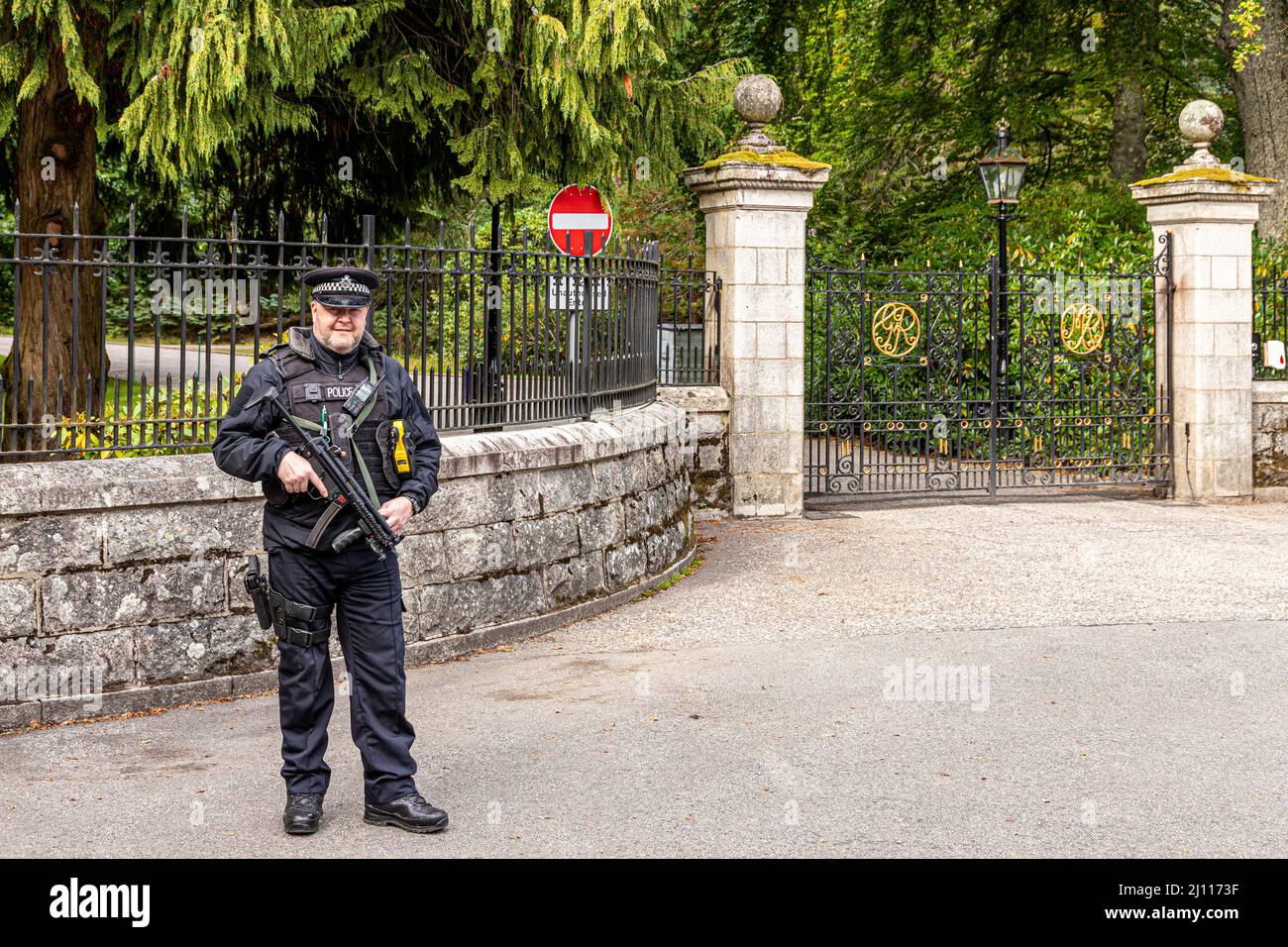 Un policía armado que vigilaba la entrada al Castillo Balmoral, Aberdeenshire, Escocia Reino Unido Foto de stock