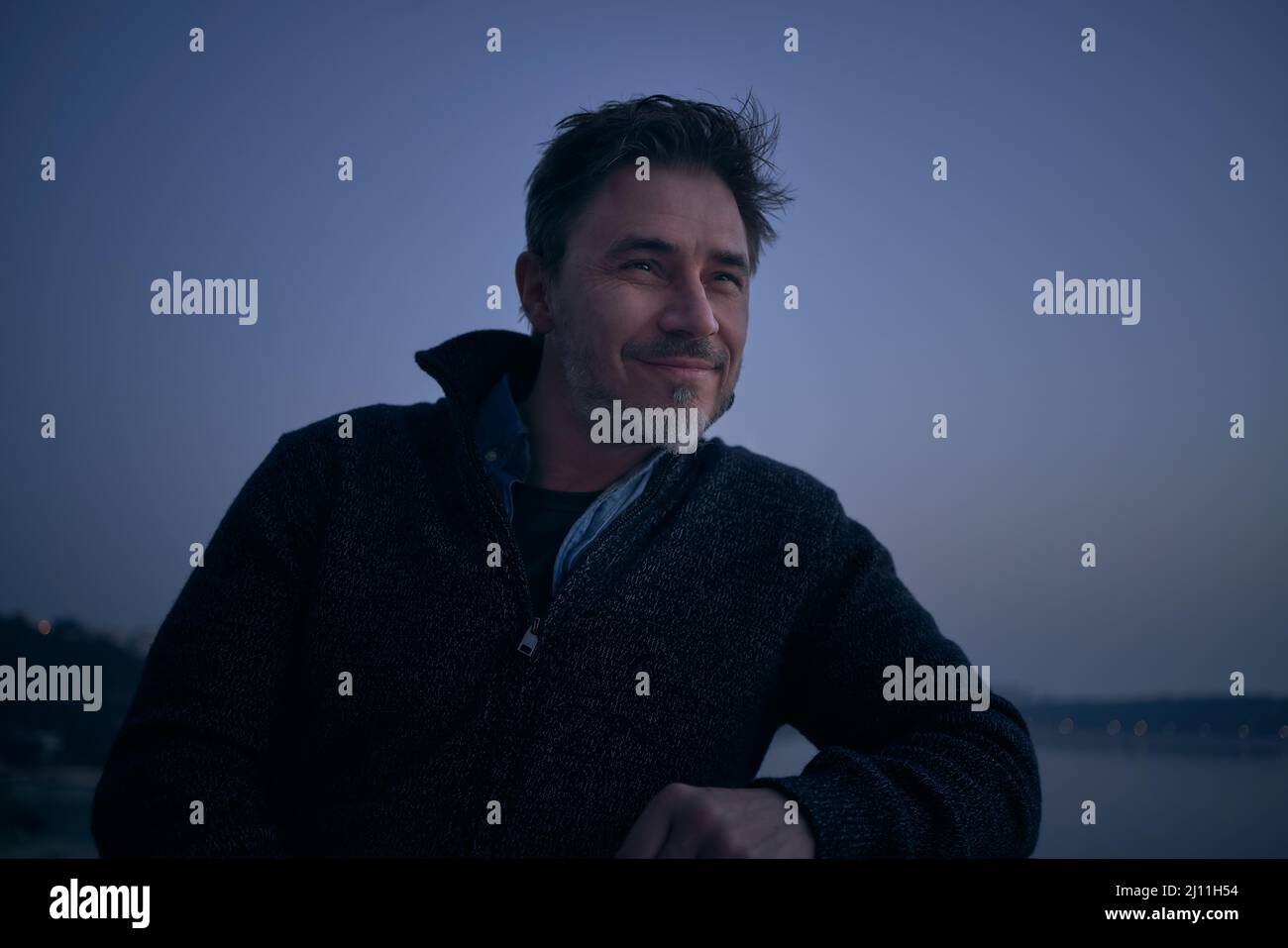 Retrato del hombre adulto medio frente al frío paisaje nórdico. Retrato de edad madura, mediana edad, hombre adulto medio en 50s, sonrisa feliz. Foto de stock