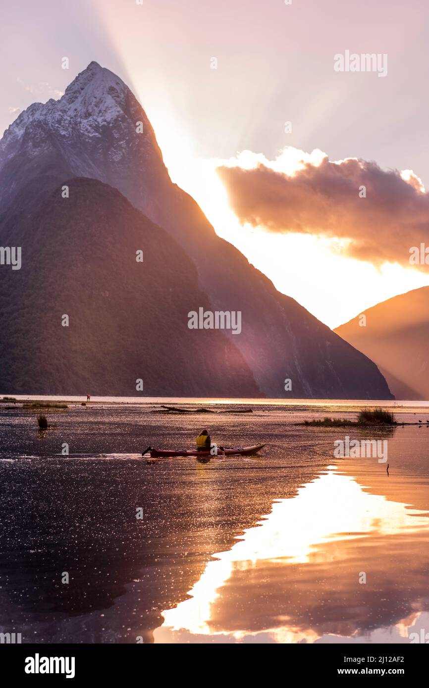Canoeista en Milford Sound durante la puesta de sol en invierno - Nueva zelanda Foto de stock