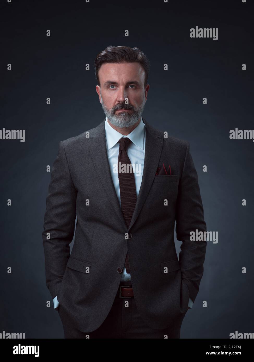 Retrato de un elegante hombre de negocios con barba y ropa de negocios  informal en un estudio de fotos aislado sobre un fondo oscuro que se viste  Fotografía de stock - Alamy