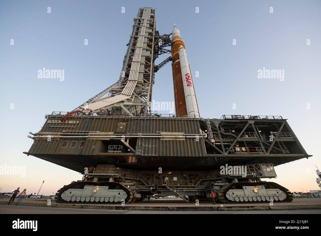 El cohete del Sistema de Lanzamiento Espacial (SLS) de la NASA con la nave espacial Orion a bordo se ve en la cima de un lanzador móvil mientras se lanza al Complejo de Lanzamiento 39B por primera vez, el jueves 17 de marzo de 2022, en el Centro Espacial Kennedy de la NASA en Florida. Antes de la prueba de vuelo Artemis I de la NASA, el cohete SLS y la nave espacial Orion totalmente apilados e integrados se someterán a un ensayo de vestido húmedo en el Complejo de Lanzamiento 39B para verificar los sistemas y practicar los procedimientos de cuenta atrás para el primer lanzamiento. Crédito de la foto: (NASA/Aubrey Gemignani) Foto de stock