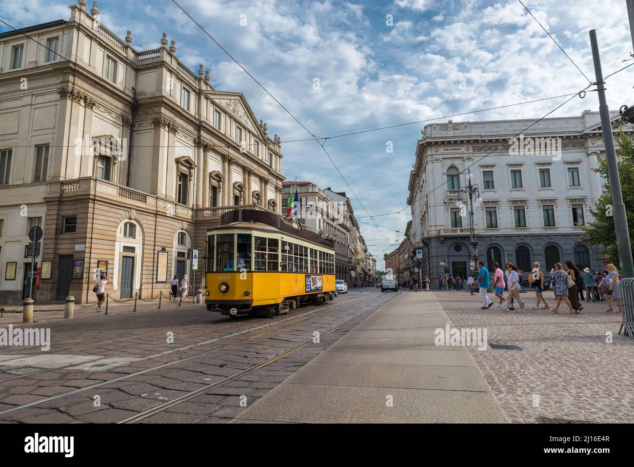 Ciudad de Milán, Italia. Piazza della Scala con el Teatro alla Scala o simplemente La Scala en el centro de Milán con un tranvía amarillo que pasa Foto de stock