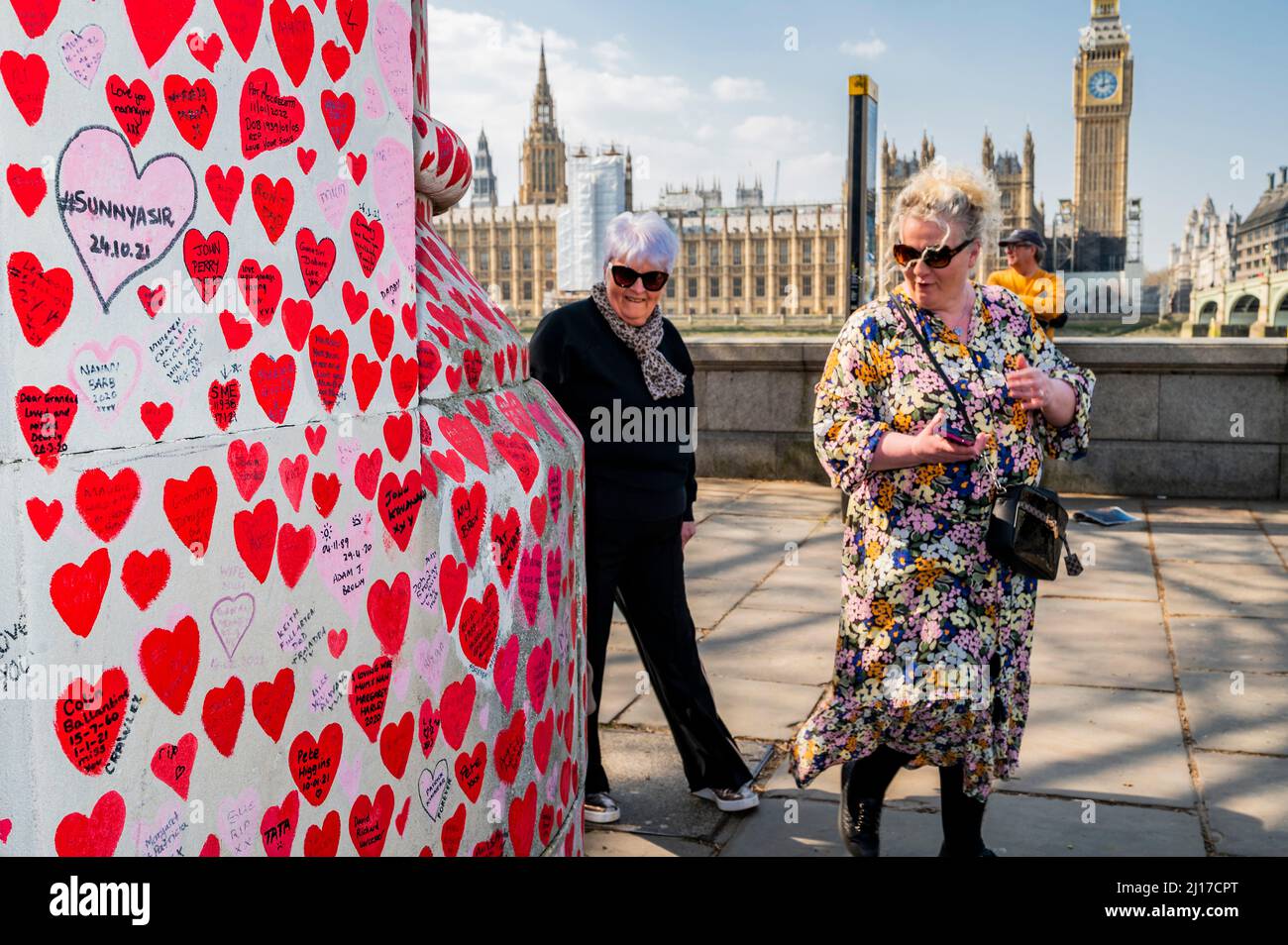 Londres, Reino Unido. 23rd Mar, 2022. El segundo aniversario del primer Lockdown - la gente todavía visita el muro nacional Covid Memorial a las afueras del Hospital St Thomas. Familiares y amigos de algunos de los más de ciento ochenta mil personas que han perdido la vida a Covid-19 han atraído corazones a mano en un muro frente al Parlamento de Londres. Fue organizado por las Familias para la Justicia de Covid-19. Crédito: Guy Bell/Alamy Live News Foto de stock