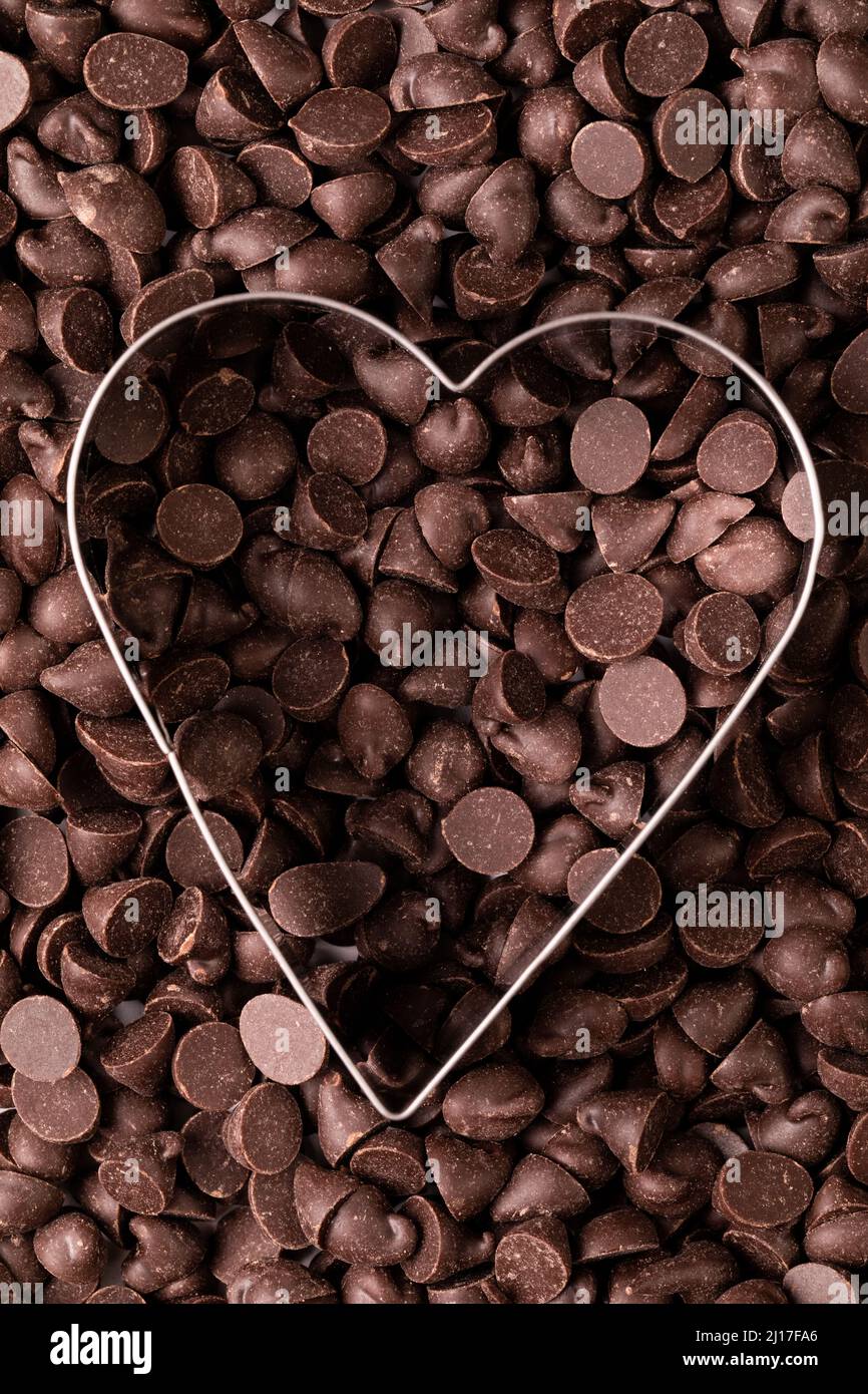 Toma completa de chips de chocolate fresco con cortador de masa en forma de corazón Foto de stock
