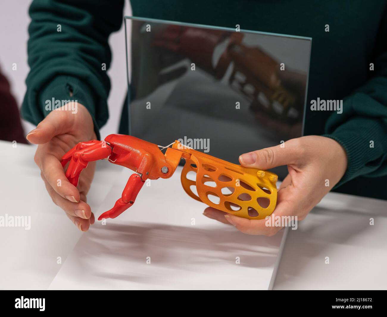 Una mujer demuestra una mano protésica de plástico para niños impresa en  una impresora 3D Fotografía de stock - Alamy
