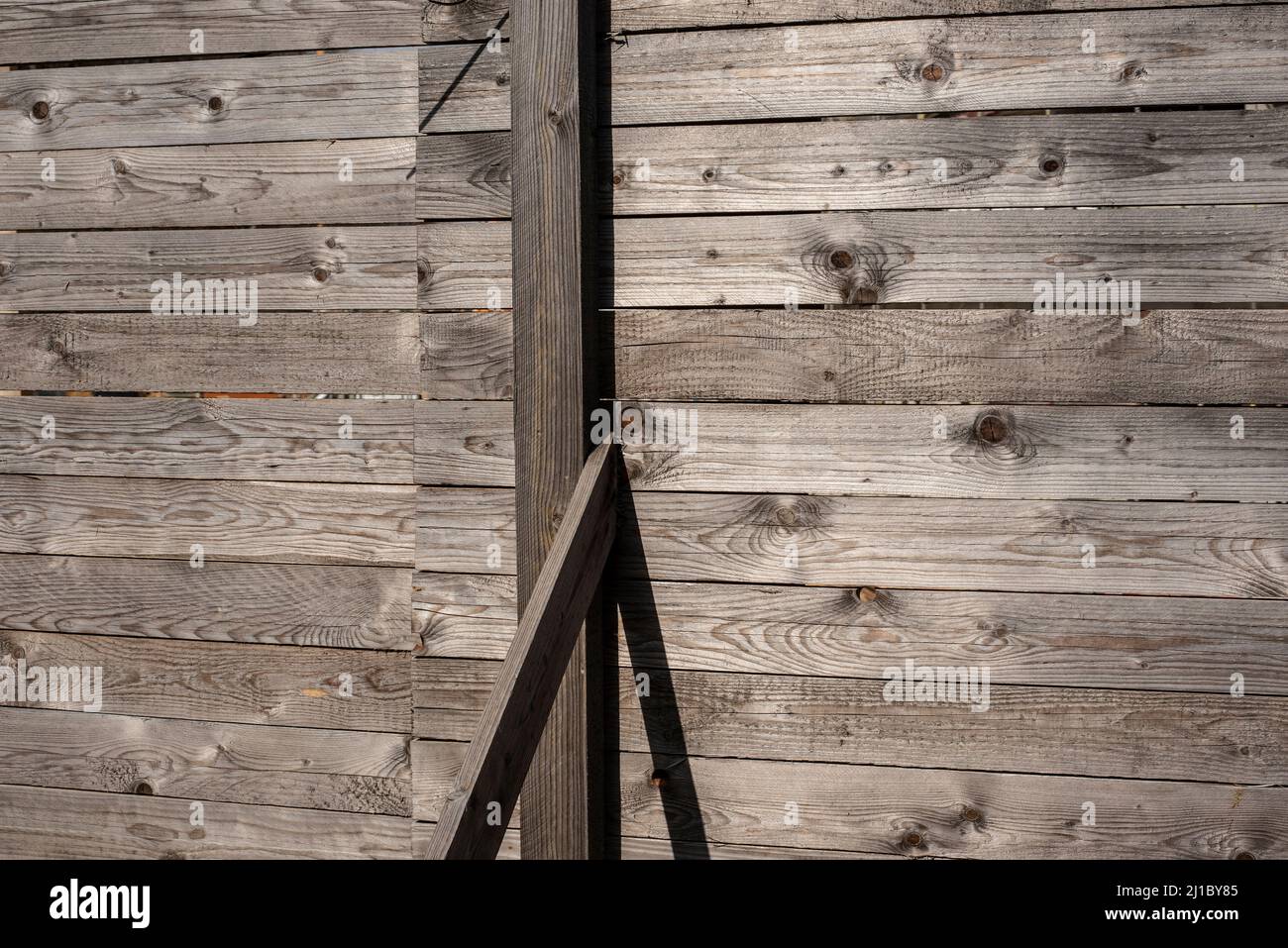 postes de madera en una cerca de tablones de pino gris envejecido Foto de stock
