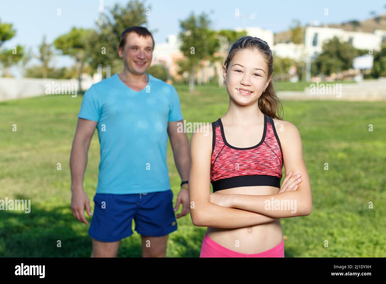 Feliz chica lista para hacer ejercicio con el padre Foto de stock