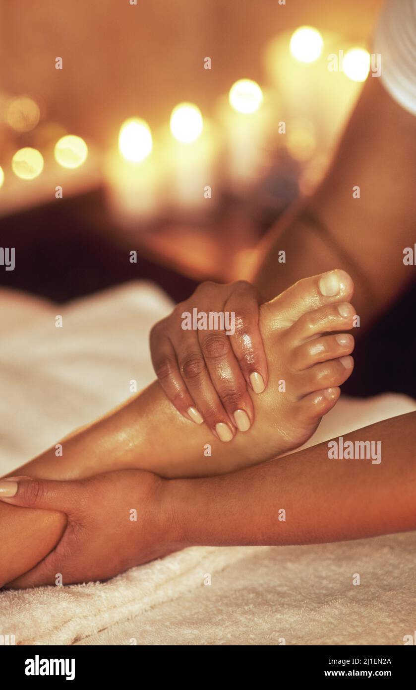 Alivie la rigidez de un día largo. Foto recortada de una mujer que disfruta de un masaje de pies en un spa. Foto de stock