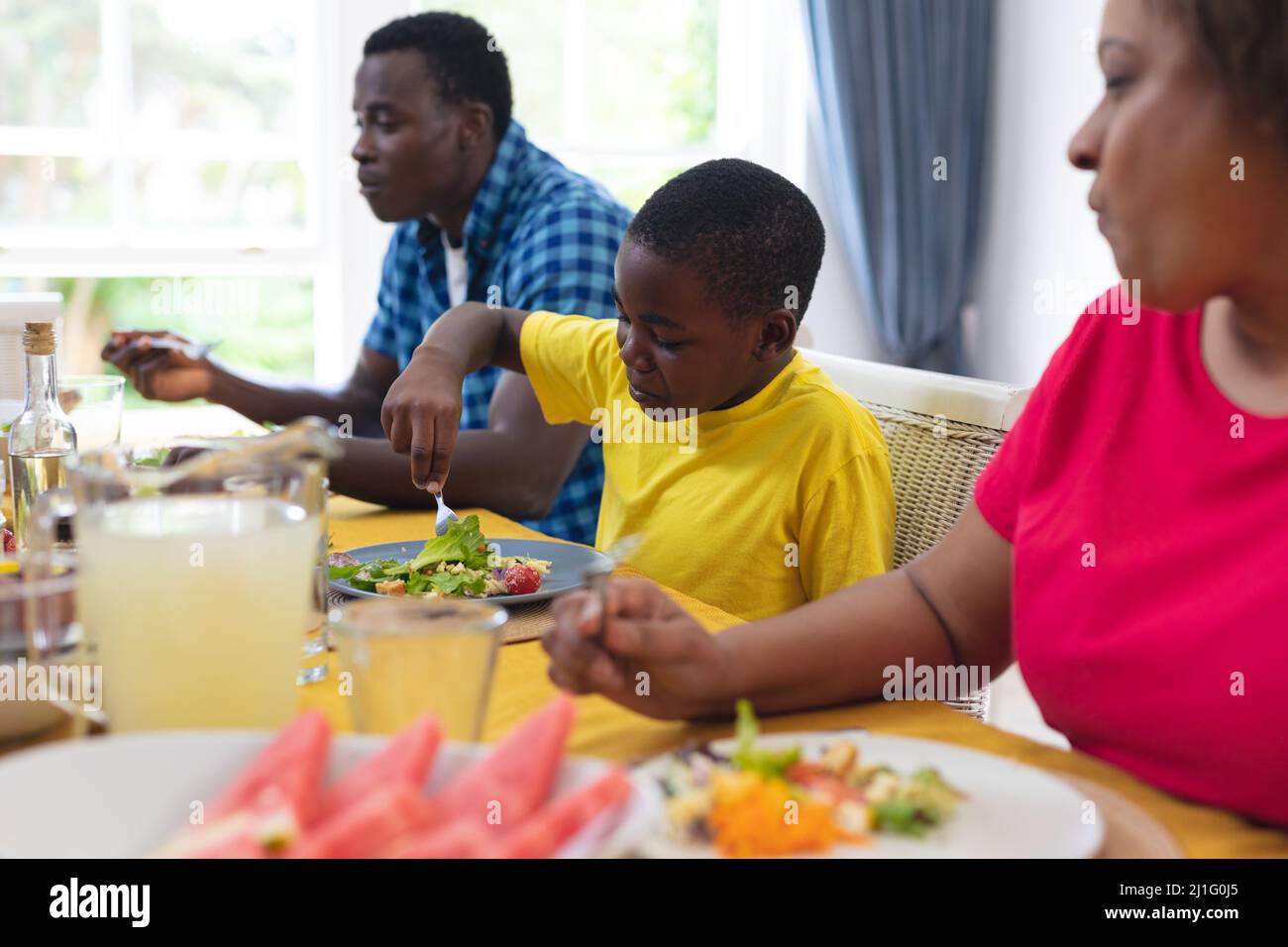 Niño afroamericano almorzando con la familia en casa el día de acción de gracias Foto de stock