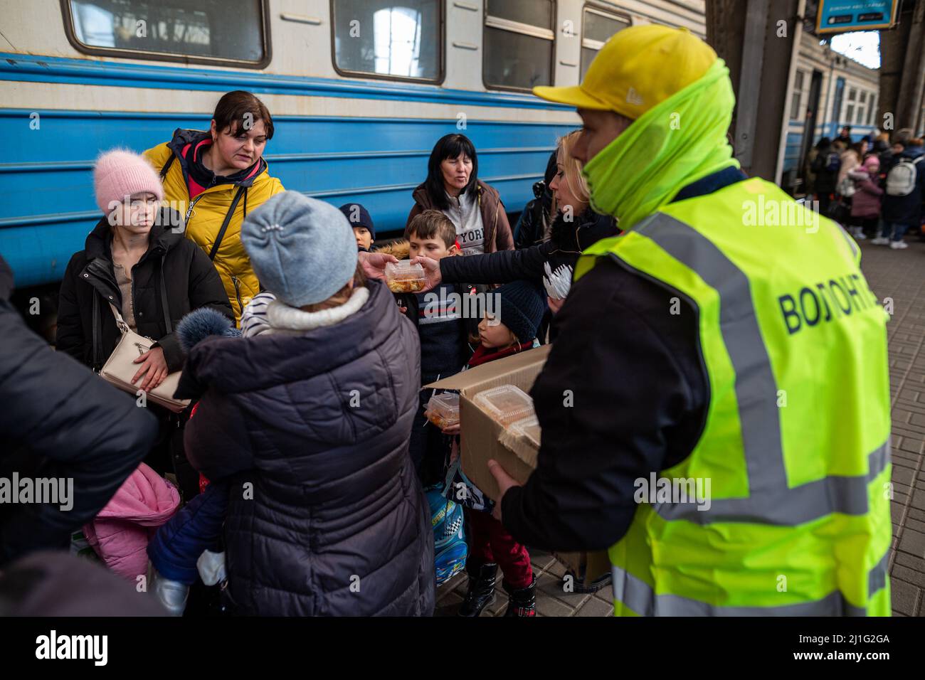 LVIV, UCRANIA - 14 de marzo de 2022: Crisis humanitaria durante la guerra en Ucrania. Los voluntarios que ayudan a alimentar a miles de refugiados huyen del territorio devastado por la guerra Foto de stock