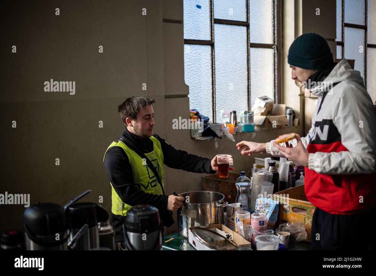 LVIV, UCRANIA - 14 de marzo de 2022: Crisis humanitaria durante la guerra en Ucrania. Los voluntarios que ayudan a alimentar a miles de refugiados huyen del territorio devastado por la guerra Foto de stock