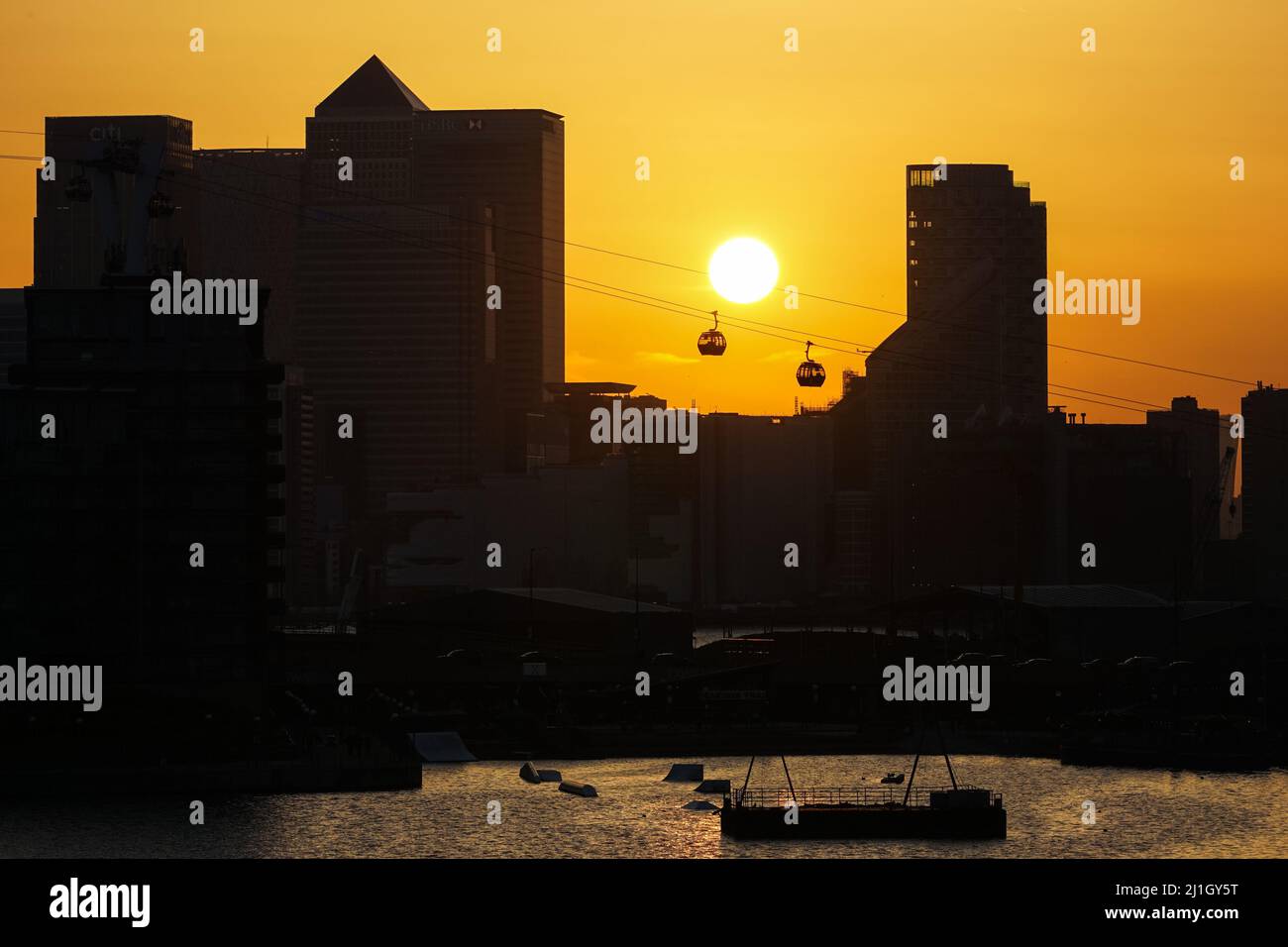 Londres, Reino Unido. 25th Mar, 2022. Clima en el Reino Unido: El sol se pone detrás de los rascacielos de Canary Wharf. Crédito: Marcin Rogozinski/Alamy Live News Foto de stock