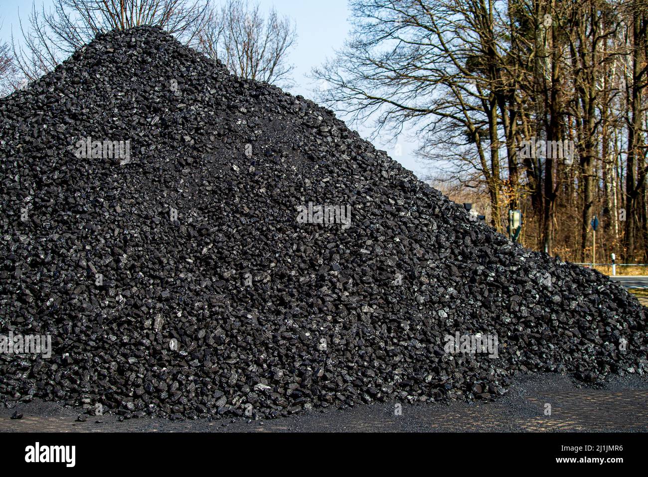 Montón de carbón negro almacenado en una estación de tren de trocha estrecha que todavía opera motores de vapor Foto de stock