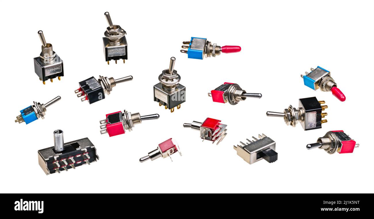 Diferentes tipos de interruptores de palanca eléctricos aislados sobre un fondo blanco. Colección de componentes electrónicos electromecánicos en miniatura para PCB. Foto de stock