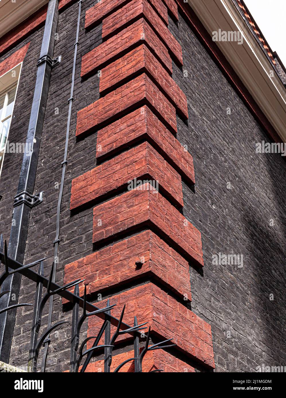 Vista en ángulo bajo de una esquina decorada con quoins de ladrillo rojo, Londres, Inglaterra, Reino Unido. Foto de stock