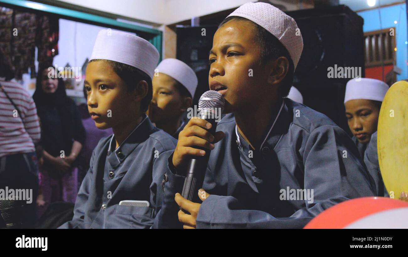 Yakarta, Indonesia - 01 02 2021: Niño sosteniendo un mic y vestido en un musulmán que llevaba una oración mientras celebraba el 72nd aniversario de la inde de Indonesia Foto de stock