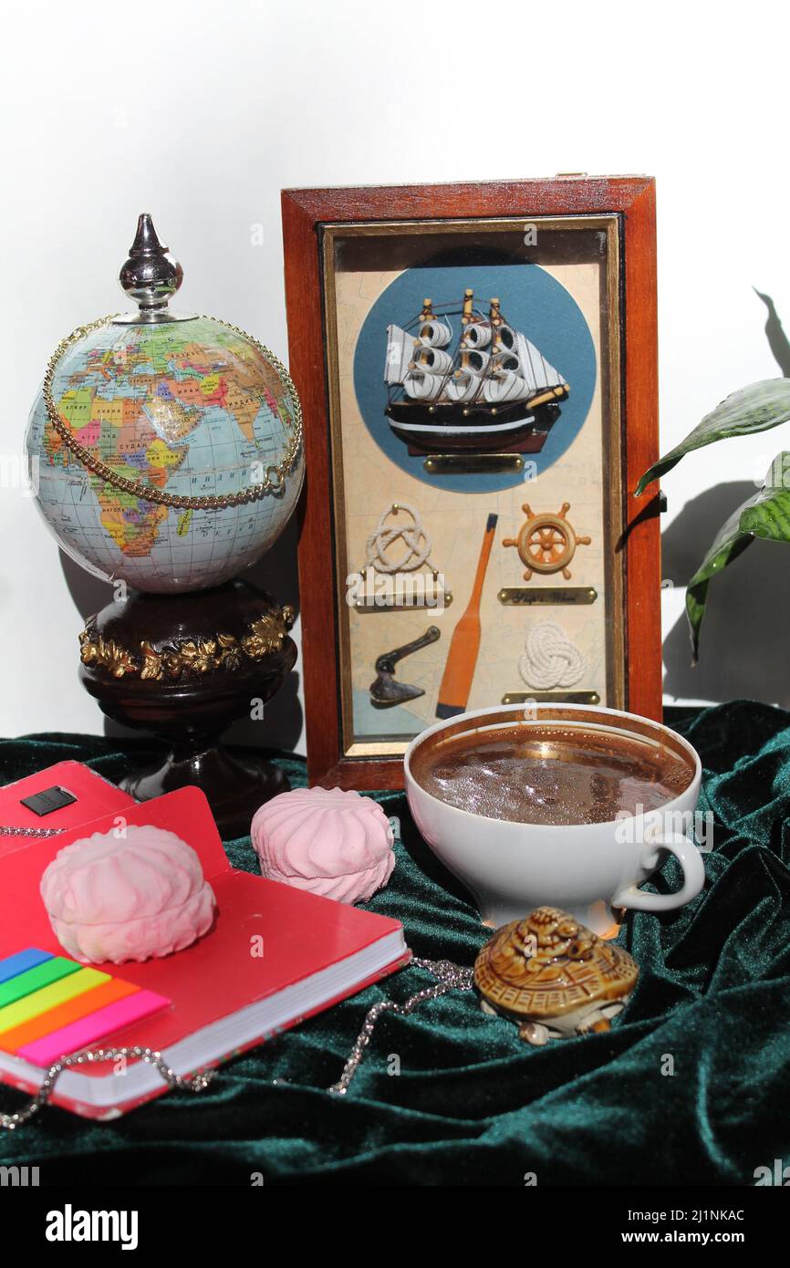 mapa globo, juguete barco de mar, malvavisco, taza de café negro caliente tiempo para soñar sobre el viaje Foto de stock