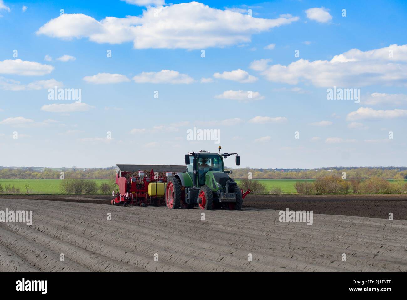 Un tractor plantando un cultivo de papa en las praderas Foto de stock