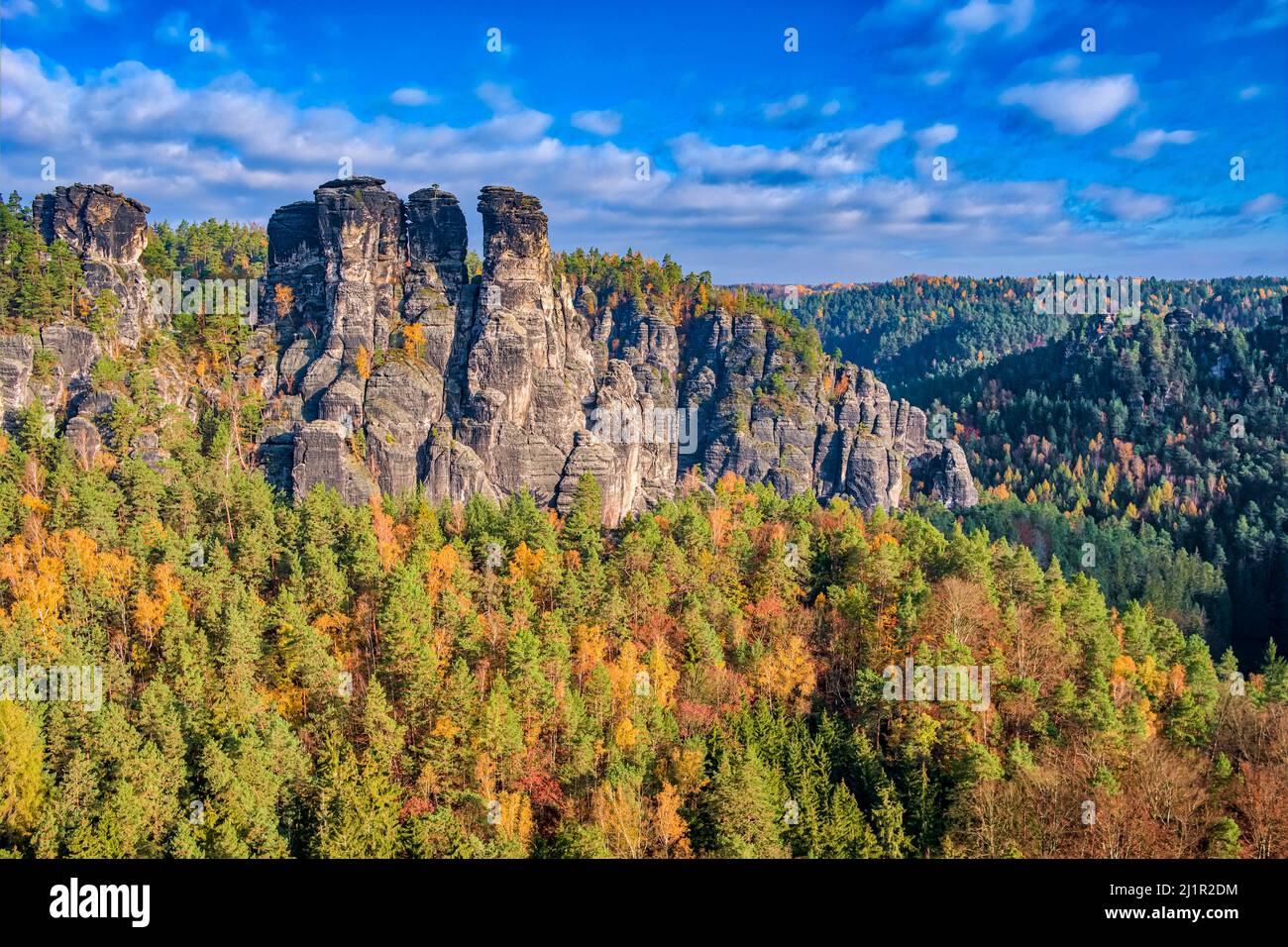 Paisaje con formaciones rocosas, la cumbre Hintere Gans y coloridos árboles en la zona de Rathen del Parque Nacional de la Suiza Saxon en otoño. Foto de stock
