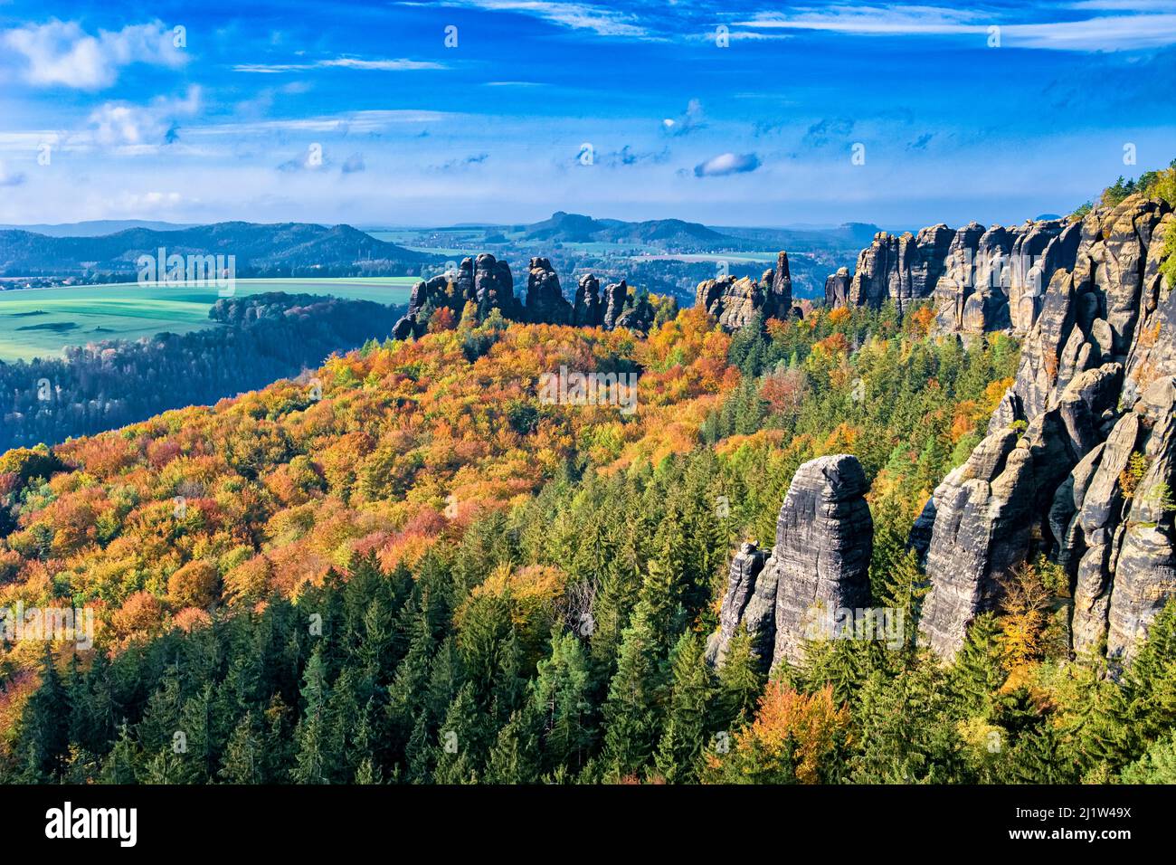 Paisaje con formaciones rocosas y coloridos árboles en la zona de Schrammsteine del Parque Nacional de la Suiza Saxon en otoño. Foto de stock