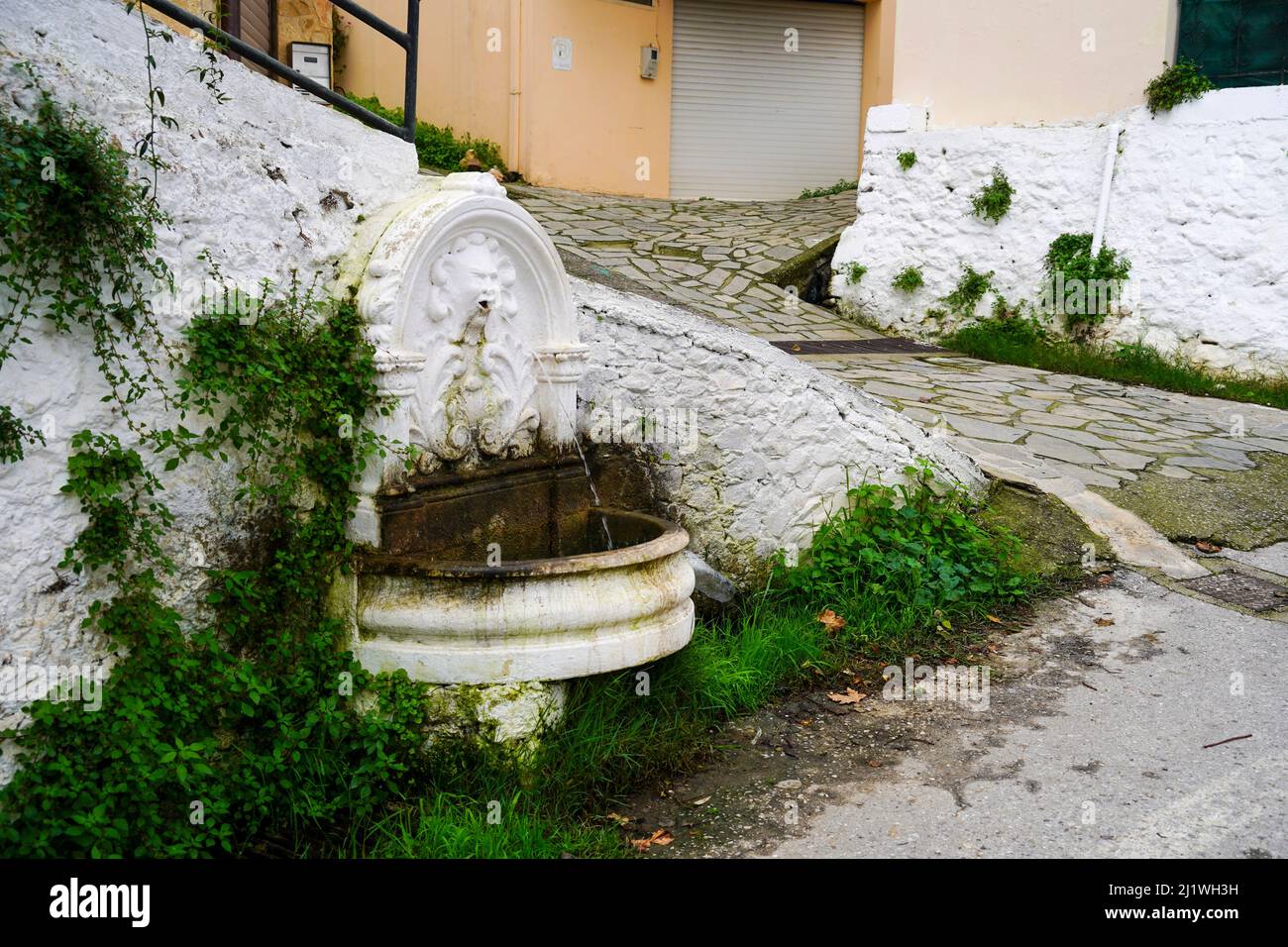 Casa tradicional griega encalada y fuente de agua pública de Chania, Creta, Grecia Foto de stock