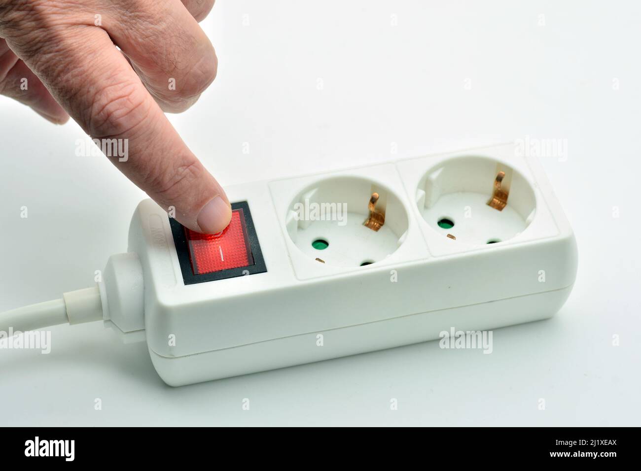 Dedo apagando un interruptor de una etiqueta eléctrica encendido, aislado sobre fondo blanco Foto de stock