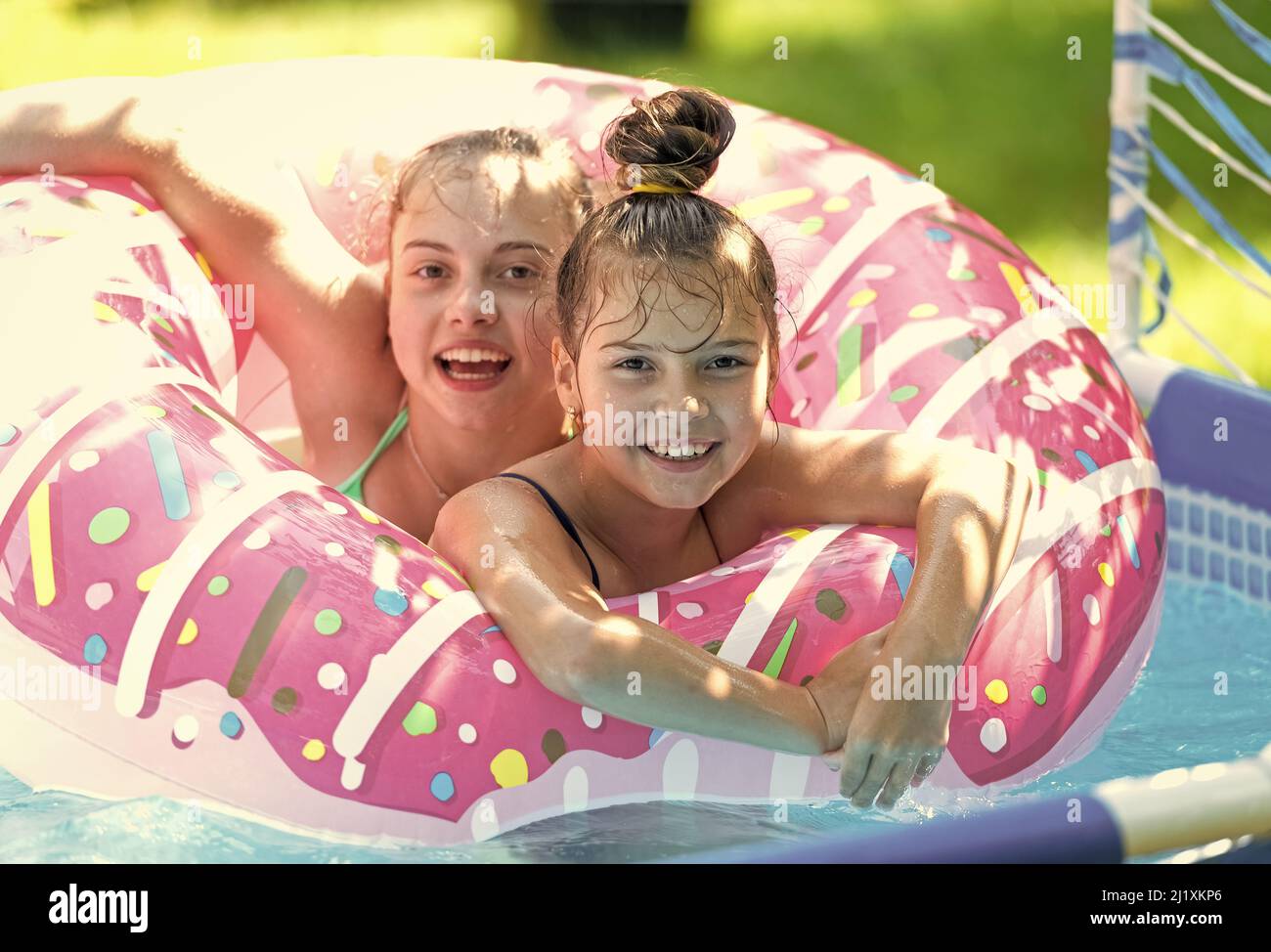 La forma perfecta de estar fresco. Los niños felices nadan en el flotador de la piscina del donut. Juegos de billar. Juegos junto a piscina. Verano Fotografía de stock - Alamy