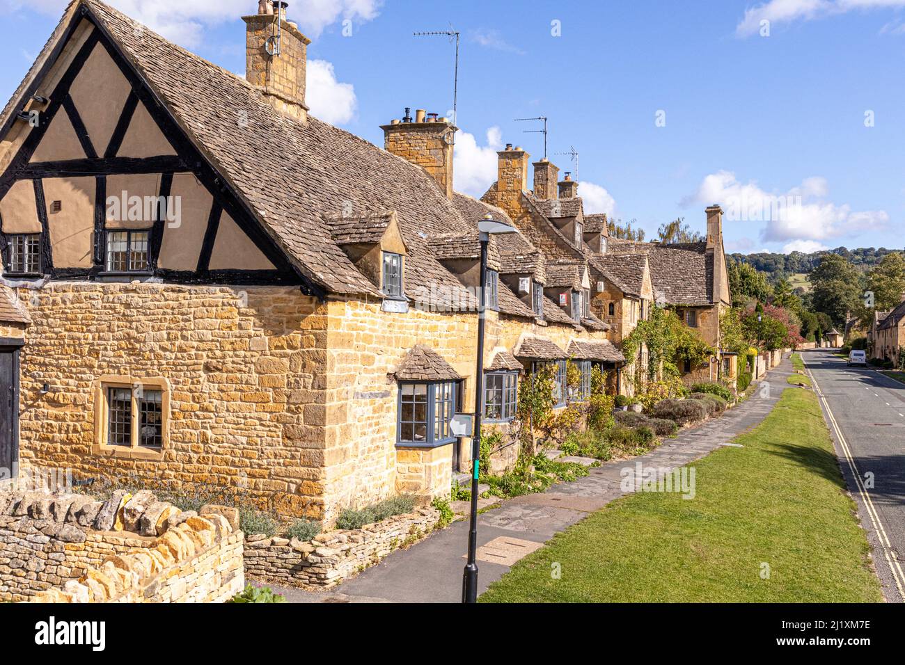 Una fila de casas de piedra antiguas en la High Street en el pueblo Cotswold de Broadway, Worcestershire, Inglaterra Reino Unido Foto de stock