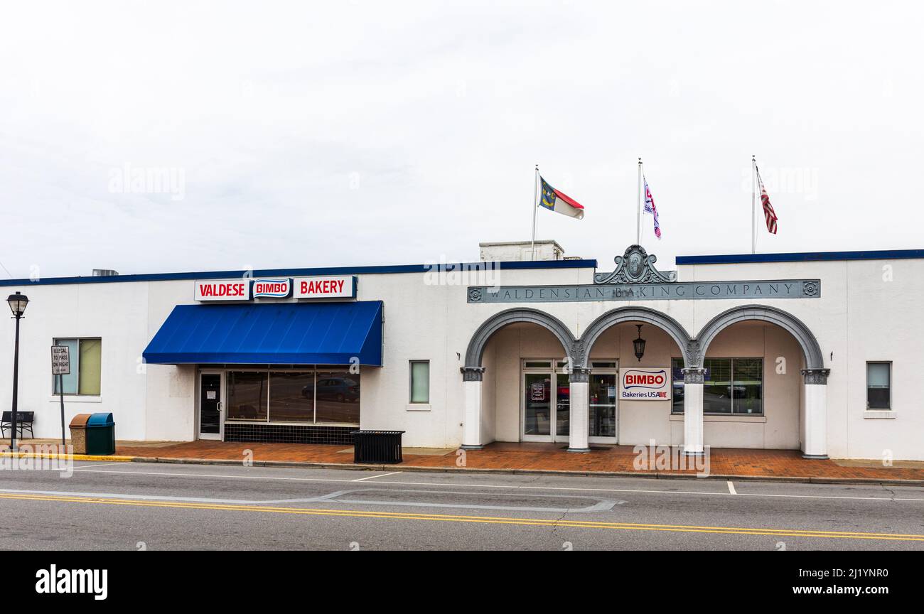 VALDESE, NC, EE.UU.-24 DE MARZO de 2022: Panadería Valdese (Bimbo), fundada como Waldensian Baking Company. Fachada frente a la calle, señales y banderas. Foto de stock