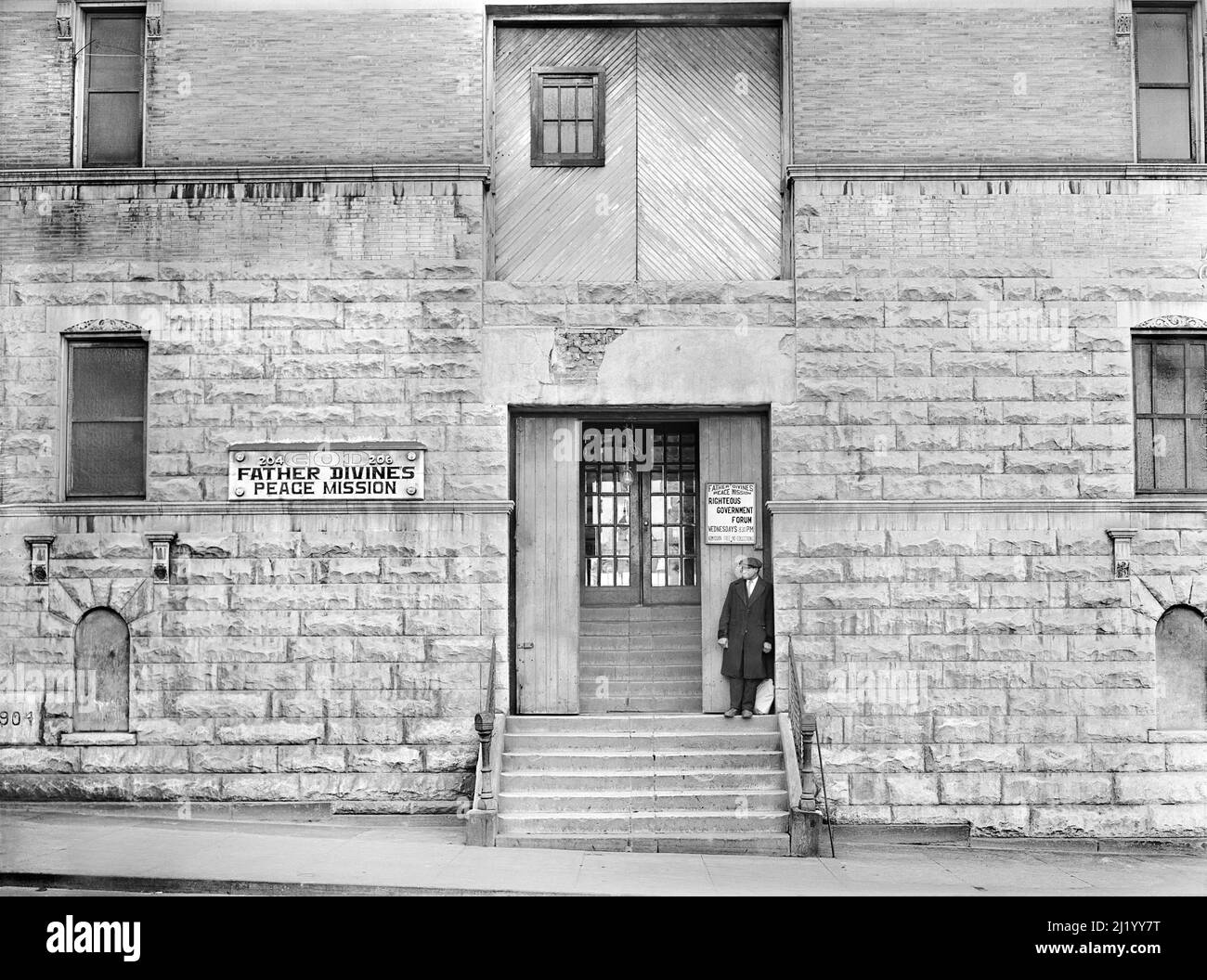 Hombre de pie en pasos de la misión de paz del Padre Divino, Harlem, Nueva York, Nueva York, EE.UU., Edwin Rosskam, Administración de Seguridad Agrícola de EE.UU./EE.UU Office of War Information, diciembre de 1941 Foto de stock