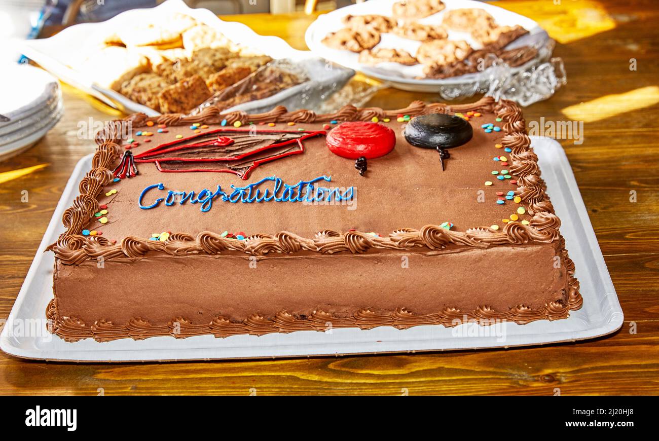 Pastel de graduación de chocolate con decoraciones y galletas en el fondo  con poca profundidad de campo Fotografía de stock - Alamy