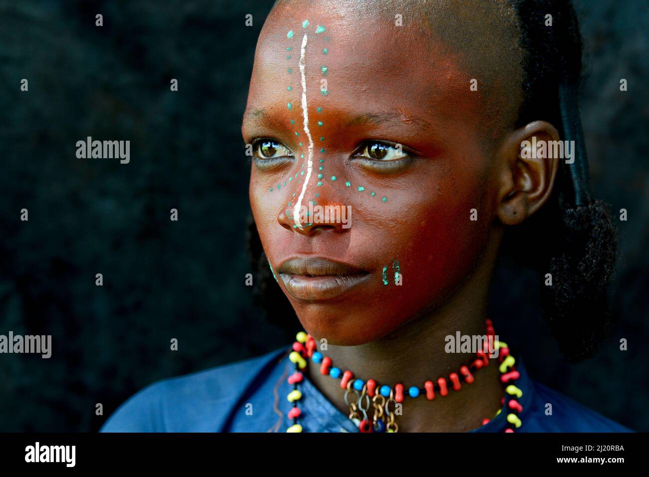 Niño de la tribu nómada de Wodaabe con rostro pintado, retrato. Durante la celebración de Gerewol, una reunión de diferentes clanes en los que las mujeres eligen a un marido Foto de stock