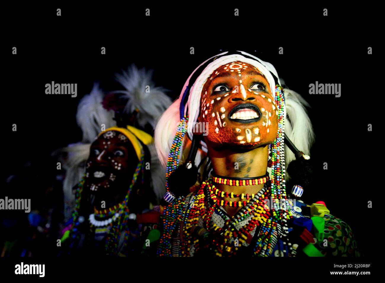 Dos hombres de grupo étnico wodaabe bailando y cantando con caras pintadas durante la celebración de Gerewol, una reunión de diferentes clanes en los que mujeres cho Foto de stock