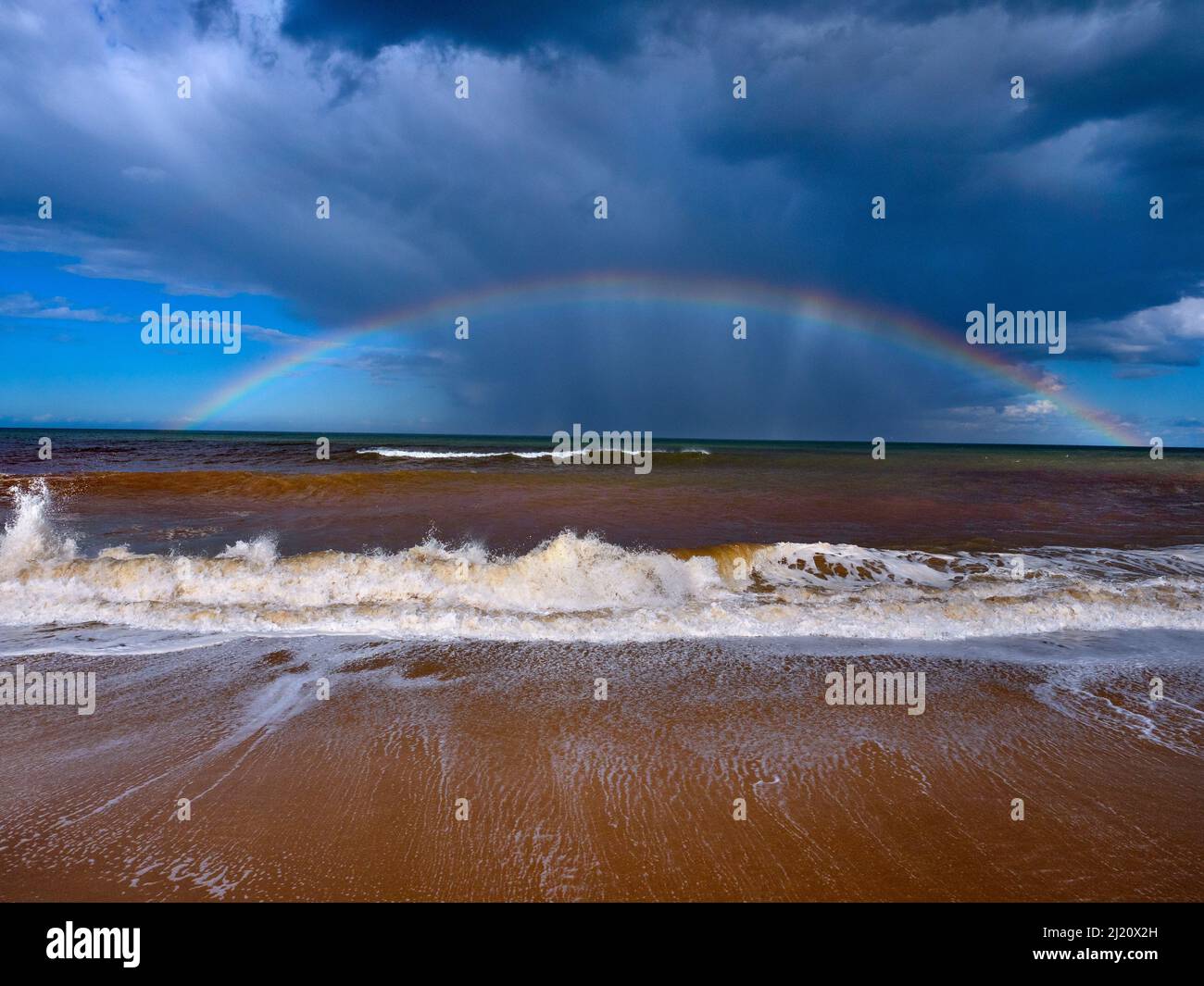 Mareas altas de otoño con cielos tormentosos y arco iris sobre el mar, Walcott, Norfolk, Inglaterra, Reino Unido, Septiembre. Foto de stock