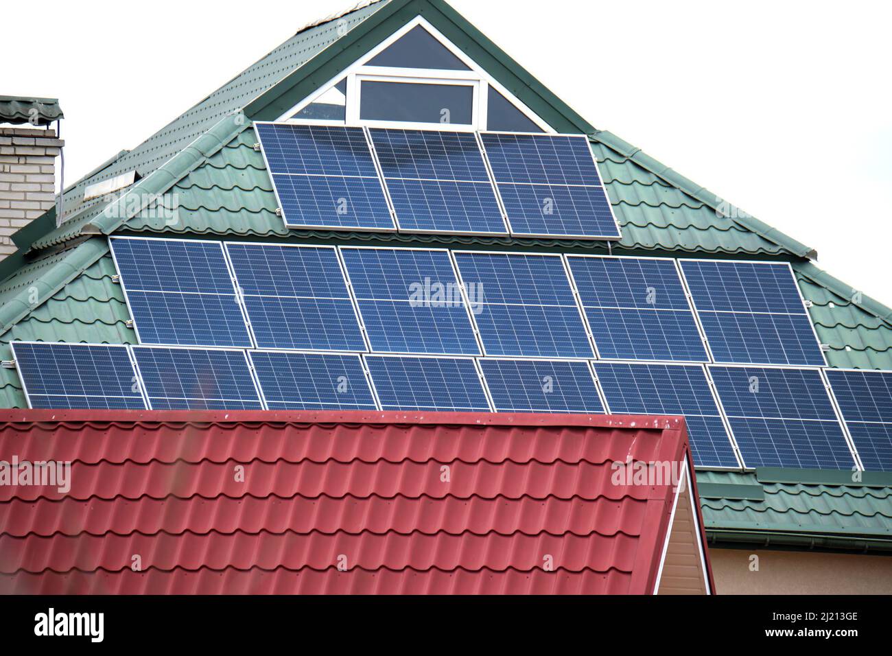 Casa residencial con techo cubierto con paneles solares fotovoltaicos para  la producción de energía eléctrica ecológica limpia en el área rural  suburbana. Conc Fotografía de stock - Alamy