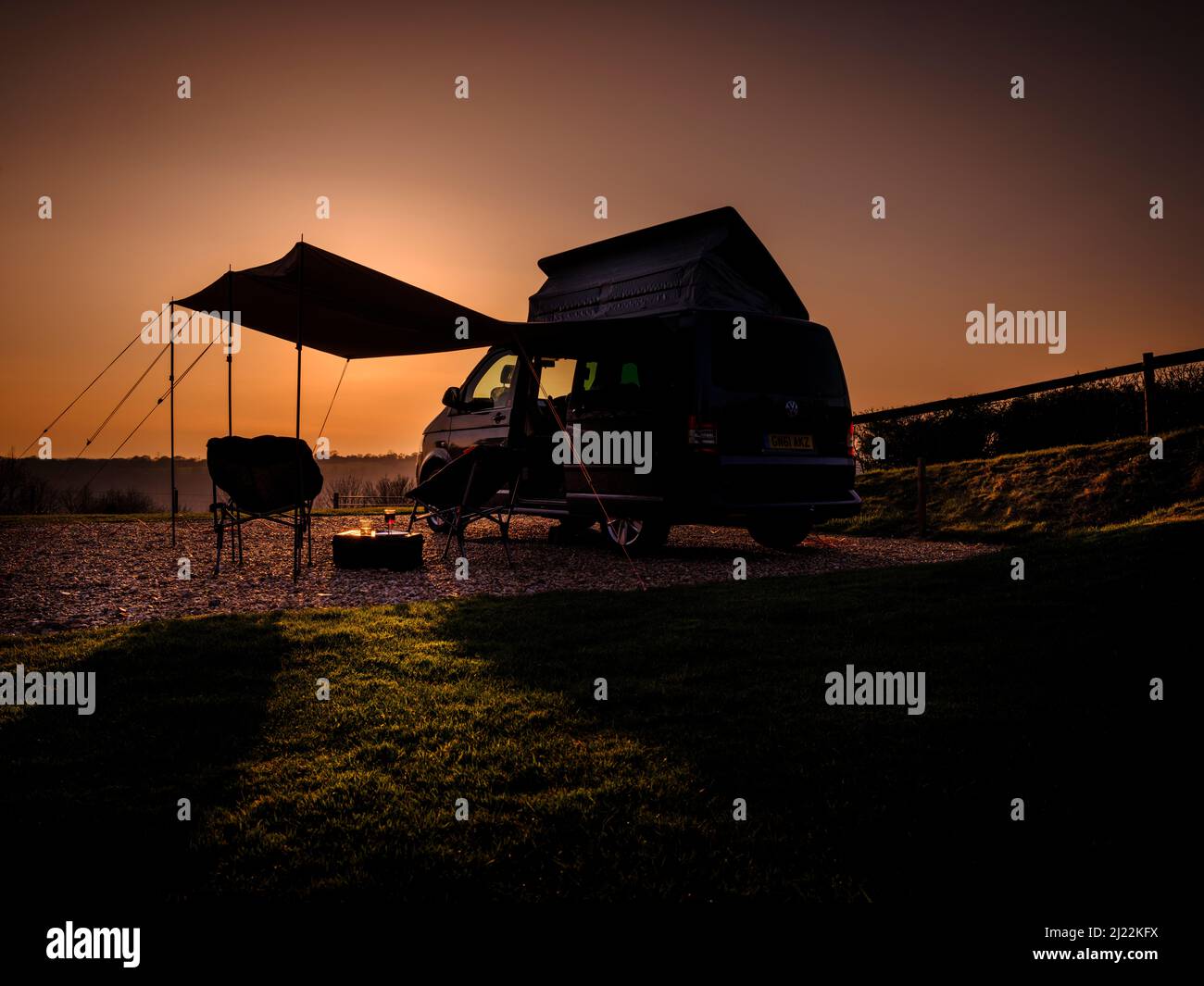 Puesta de sol en los South Downs en Bow Hill Farm. Reino Unido camping vanlife con una camioneta VW T5 camper y toldo. Foto de stock