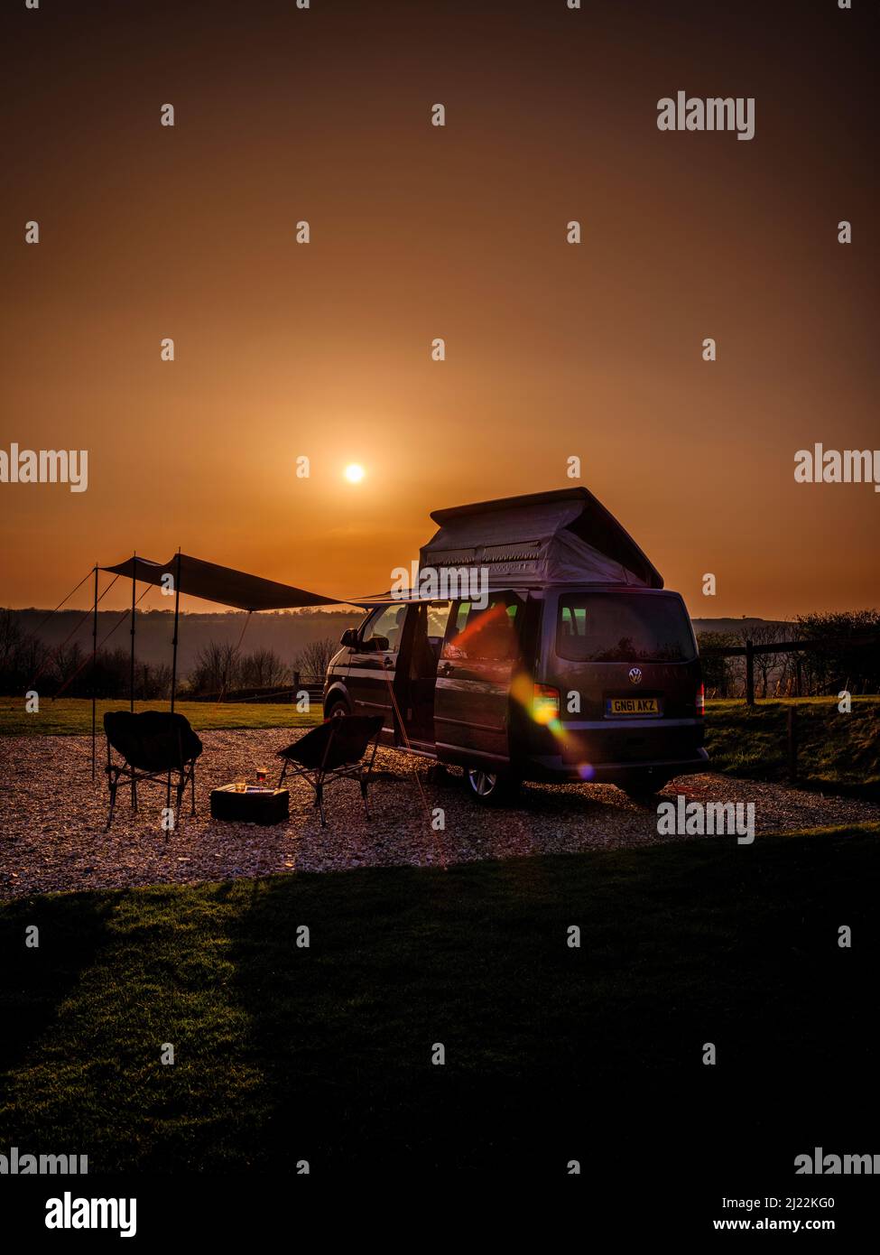 Puesta de sol en los South Downs en Bow Hill Farm. Reino Unido camping vanlife con una camioneta VW T5 camper y toldo. Foto de stock