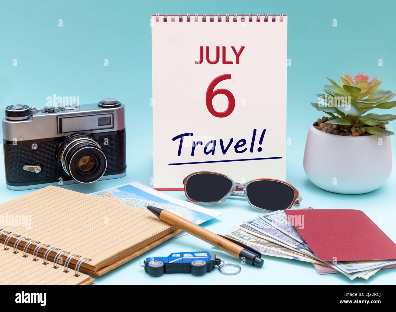 6th días de julio. Planificación de viajes, viaje de vacaciones - Calendario con la fecha 6July gafas bloc de notas cámara lápiz pasaporte en efectivo. Mes de verano, día del año Foto de stock