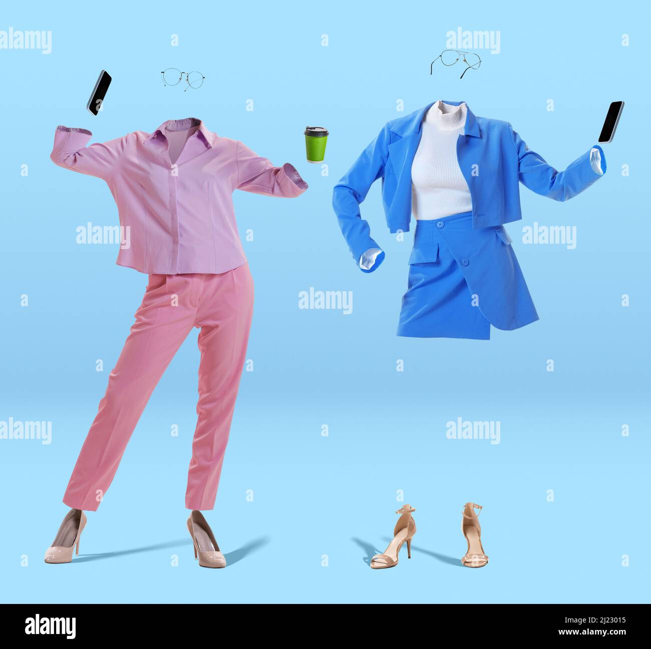 Dos mujeres invisibles con estilo que usan conjuntos de estilo moderno sport y gafas con teléfonos sobre fondo azul. Concepto de moda, estilo Foto de stock