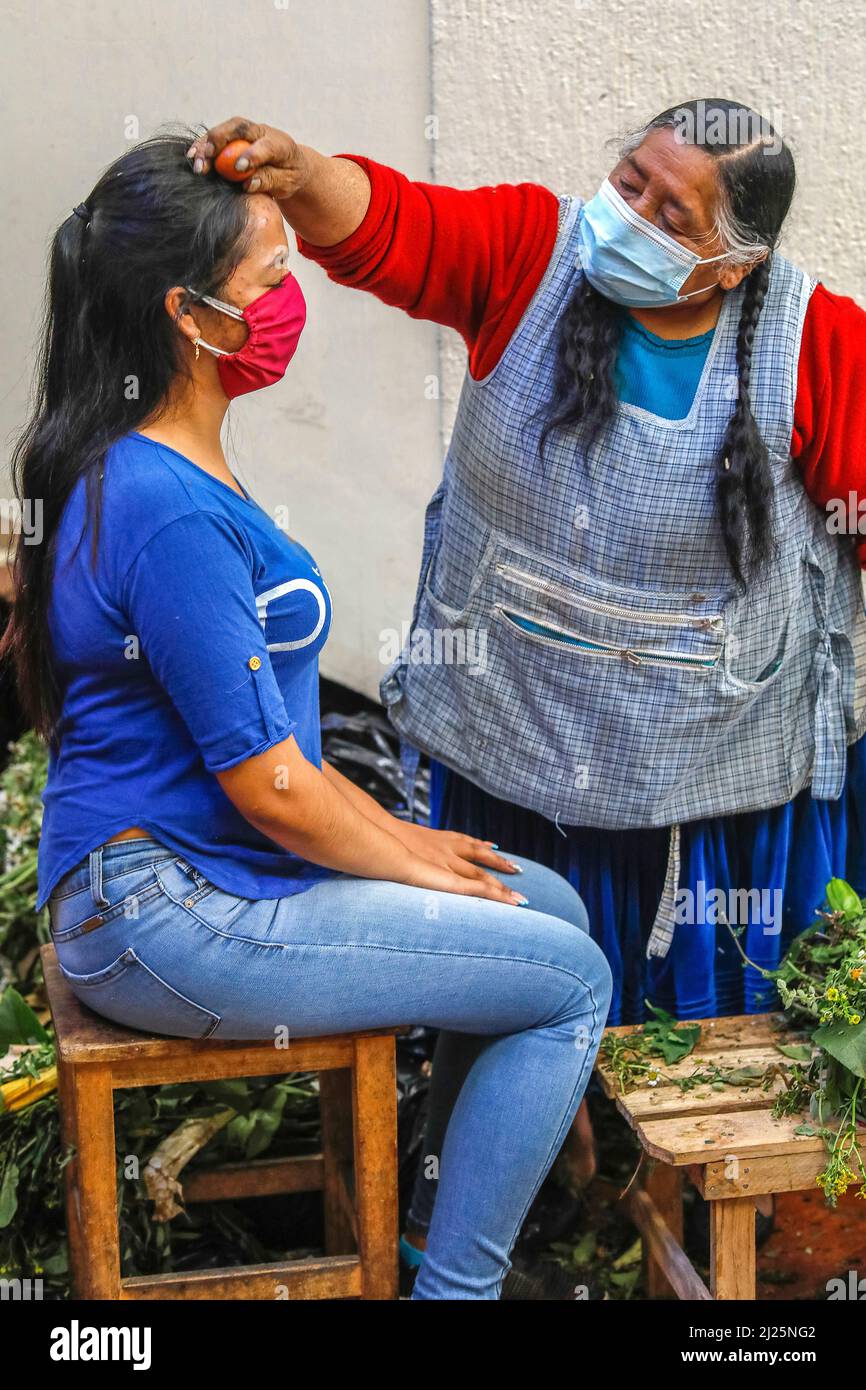 Decano Compulsión sorpresa Mujer indígena realizando una limpia (masaje con hierbas y huevos) en un  centro comercial de Cuenca, Ecuador Fotografía de stock - Alamy