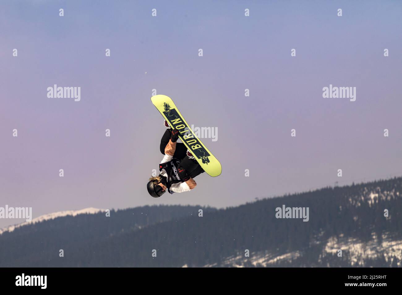 SPINDLERUV MLYN, REPÚBLICA CHECA - 18th de marzo. 2022: Snowboarder saltando contra el cielo azul. Snowboard. Un joven snowboarder salta en el Spindleruv ML Foto de stock